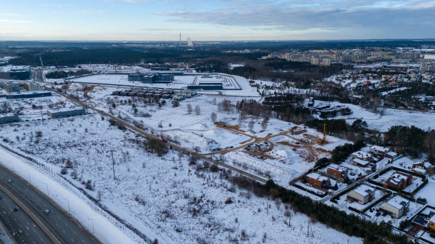 istock Drone photography construction site covered by snow and heavy equipment working, surrounded by underdeveloped city suburb during winter day 2149263605
