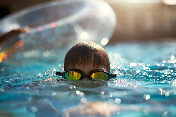 istock Little boy enjoying playing in a resort swimming pool 2149264625