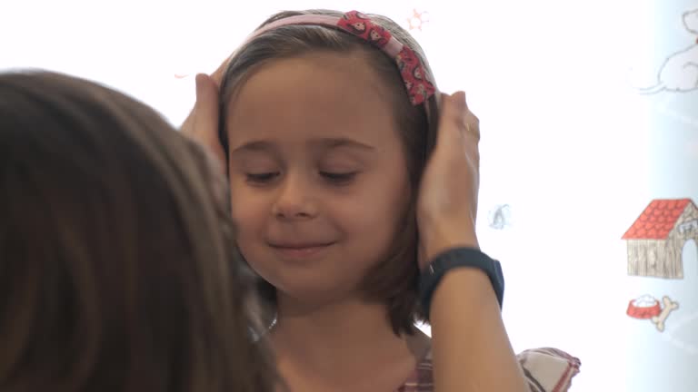 Mom puts the crown of hair on her little girl