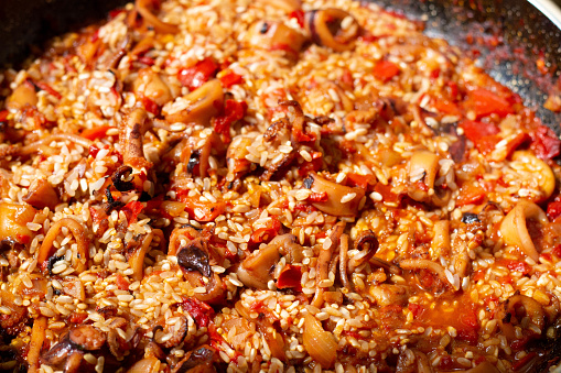 Witness the pivotal moment as rice joins the aromatic sofrito, enhancing the essence of traditional Spanish paella
