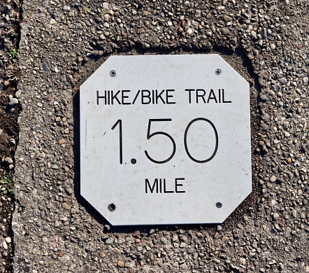 A close view of the silver metal mile marker.