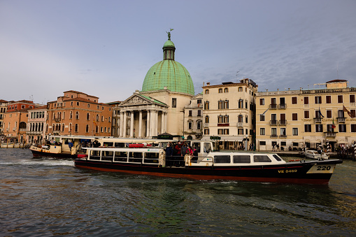 Chiesa di San Simeon Piccolo (Church of San Simeon piccolo) is one of many different cathedrals in Venice. This one sits alongside the Grand Canal and known for its dome roof. Here a water taxi goes in front.