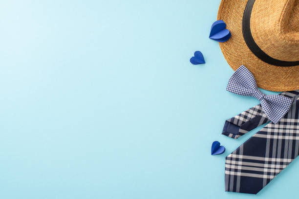 istock Perfect for Father's Day, this image features a stylish straw hat, a checkered tie, and blue hearts on a soft blue background 2149267196