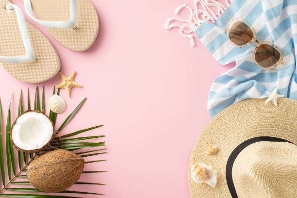 istock Flat lay of summer vacation items including flip-flops, sunglasses, straw hat, and coconuts on pink background, depicting a tropical holiday 2149267205