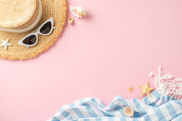 istock A stylish flat lay of summer beach essentials including a straw hat, white sunglasses, and seashells on a pink background, conveying a vacation vibe 2149267216