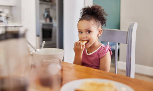 istock Baby girl eating cookie for breakfast at dining table 2149267838