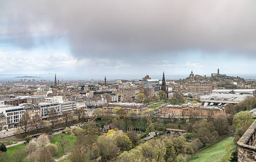 View of Edinburgh Skyline including Carlton Hill, the St James Quarter building, with rain clouds over the Firth of Forth in the distance from Edinburgh Castle looking north east