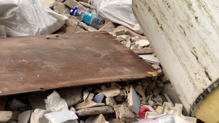 Weathered wooden plank and rubble in garbage container