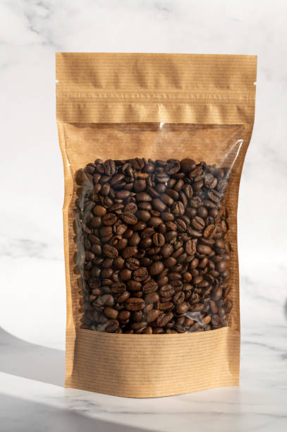 istock A kraft paper bag with coffee beans for viewing with a highlighted shadow lies on a white background 2149270319