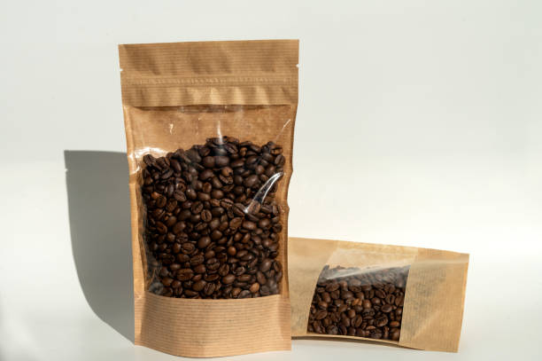 istock A kraft paper bag with coffee beans for viewing with a highlighted shadow lies on a white background 2149270339