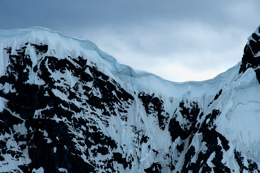 A blue cornice on mountains in Antarctica.