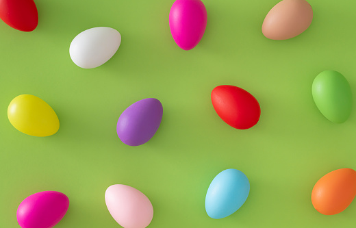 Creative Easter pattern composition made with colorful Easter eggs on light green background. Minimal Easter concept. Spring holiday pattern background. Flay lay, top of view.