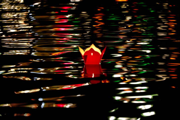 Colorful lamp floats around the tranquil river among light reflections Hoi An, Vietnam.