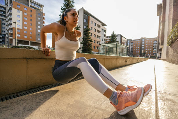 istock Young woman stretching and warming up before training outdoors 2149271544