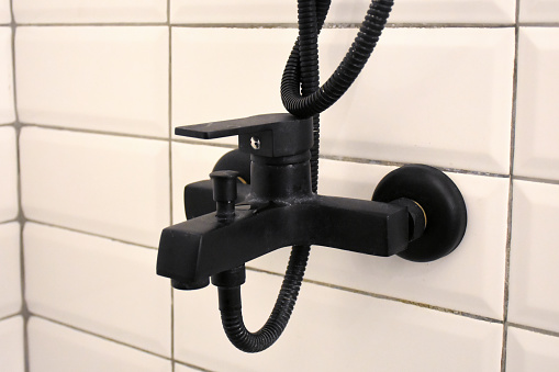 Bathroom shower faucet on ceramics tile wall
