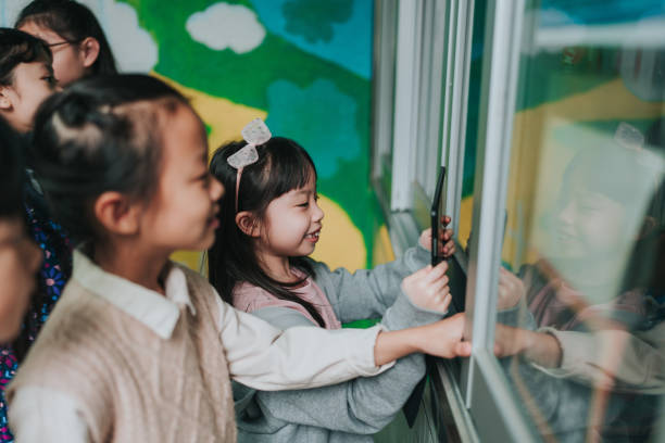 istock A group of children are looking at something through a window. 2149274926