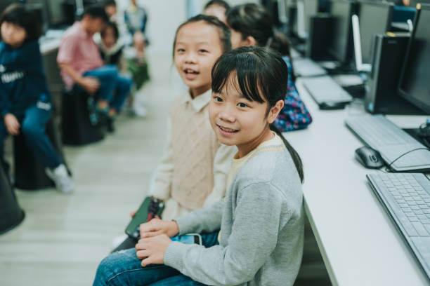 istock Two young girls sitting and smiling at the camera. 2149275465
