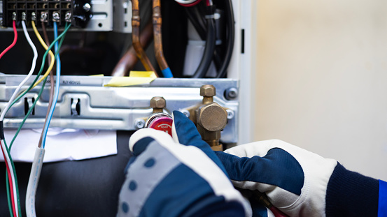 Close-up Air conditioner technician hand check  fill refrigerant liquid and maintenance condenser unit, Home care service