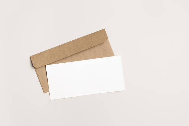 istock Blank paper card mock up and craft envelope on beige White empty festive invitation on table. Open paper letter mockup. Minimal modern lifestyle photo. Flat lay, top view, copy space. 2149275733