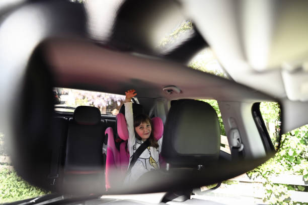 Girl having fun in a car. view from a rear view car mirror.