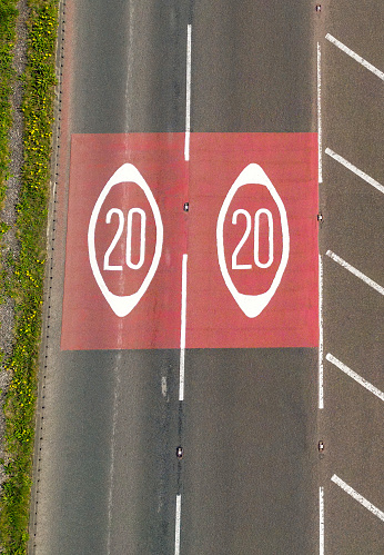 Drone view of road markings in Wales showing the start of a 20mph speed limit zone.
