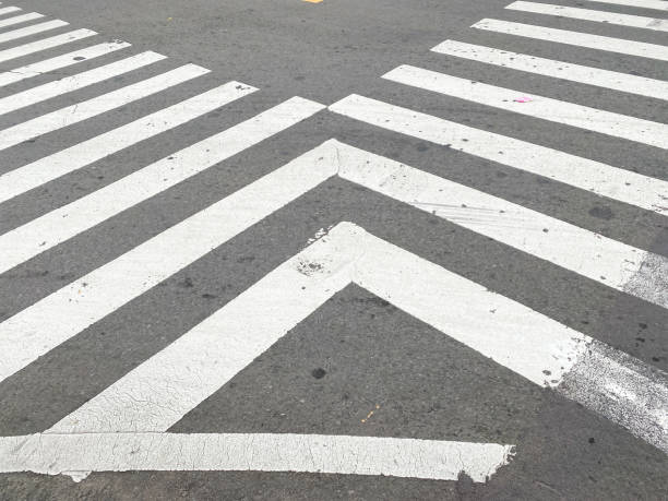 pedestrian crossing, white stripes on black asphalt, road markings zebra crossing, place to cross the road, traffic rules. crosswalk on the road for safety when people walking cross the street.