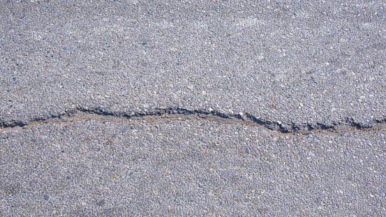 Crack line texture on surface of the old asphalt road background, top view with copy space