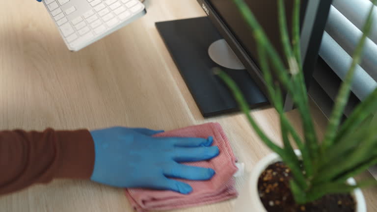 A person wearing gloves is typing on a keyboard