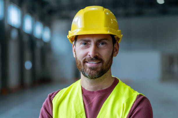 istock Smiling, attractive, bearded man wearing yellow hard hat looking at camera. Professional worker 2149277425