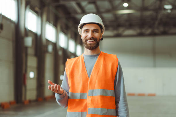 istock Bearded, professional foreman wearing protective white helmet and workwear explaining something 2149277432
