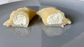 Dumpling with cheese cut in half on a gray plate