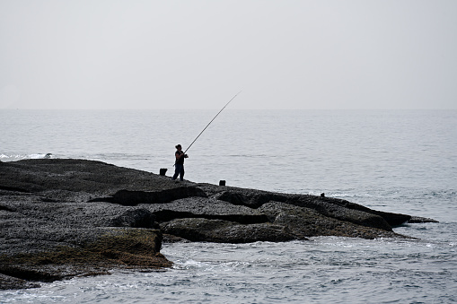 Portrait of an old man fishing in the sea. Fishing concept.