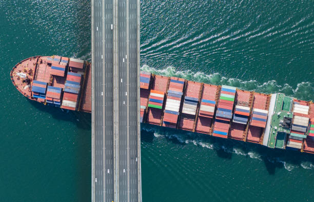 istock Aerial view of a cargo ship passing under bridge. 2149279637