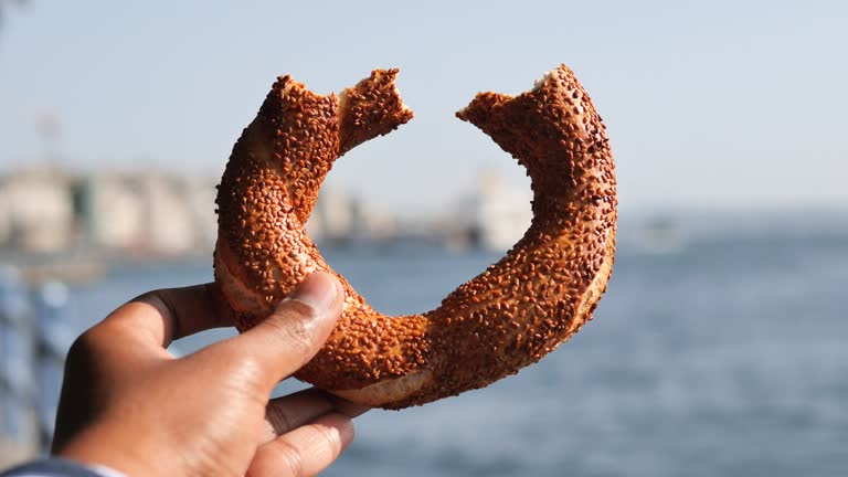 holding a Turkish Bagel Simit against istanbul city background