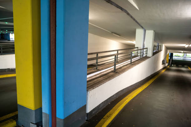 Closed parking barrier at the entrance of a multi-level garage with ramp and yellow arrows