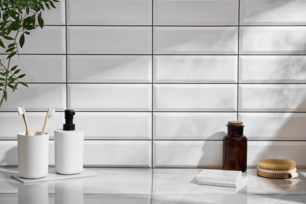 Marble shelf in the bathroom with various objects against a background of white tiles