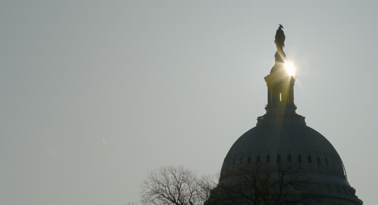 U.S. Capitol Dome and Statue with Sunrise Crossing Behind