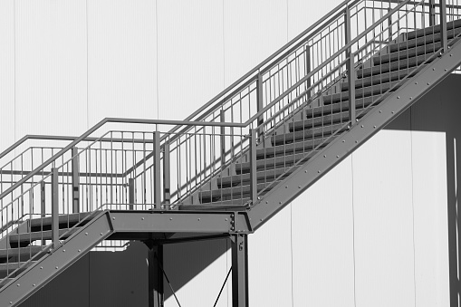 greyscale shot outdoor stairway to the building in the sun