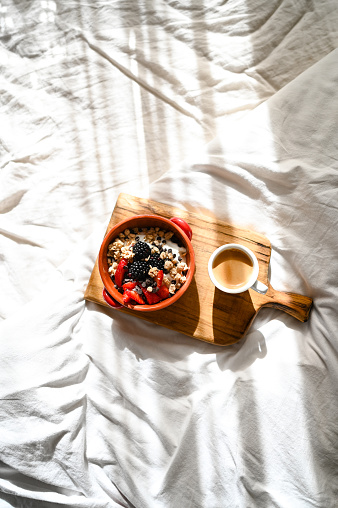 Top view of a healthy breakfast on a bed in sunny morning.