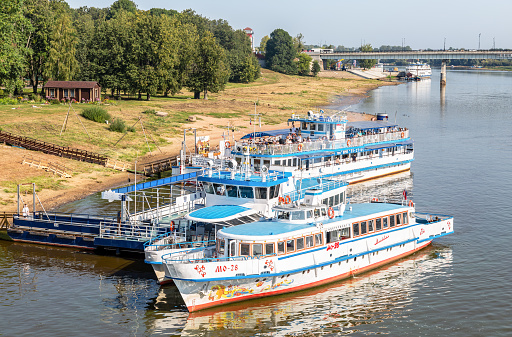 Veliky Novgorod, Russia - August 27, 2022: River cruise passenger ships a moored on a Volkhov river in summer sunny day