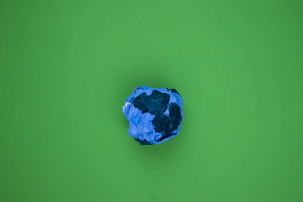 Planet earth made of paper against green background for Earth Day concept.