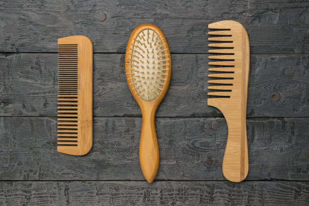 istock Three wooden combs on a black wooden background. 2149285039