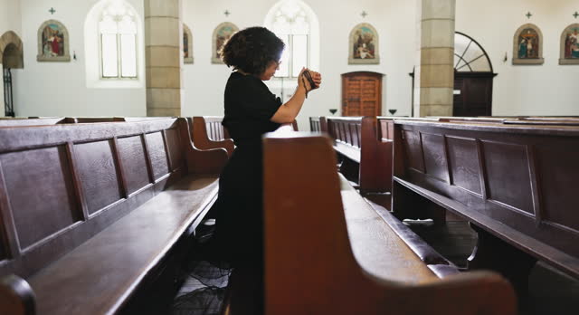 Woman, sad and praying at church with respect, alone and religion for grief with comfort, gratitude and confess. Hope, spiritual and trust with support before memorial service or wake for funeral