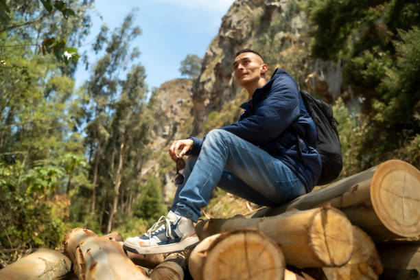 istock Man sitting on some large logs looking at the landscape 2149294958