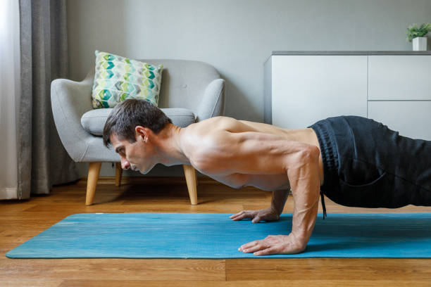 istock Man in chaturanga pose doing vinyasa flow at home. 2149295361