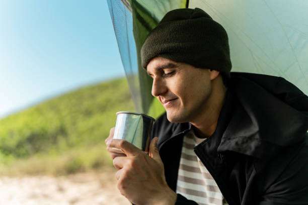 istock Mid adult man drinking coffee and camping on the beach 2149296932