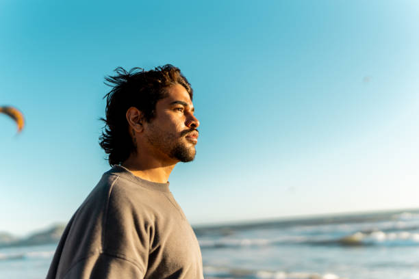 istock Young man contemplating and looking at view on the beach 2149296945