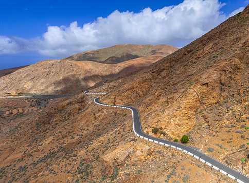 The narrow, winding and steep road running through the dramatic volcanic mountain landscape of Fuerteventura in The Canary Islands Spain