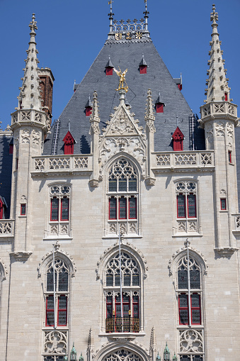 Bruges, Belgium - May 19, 2023: Medieval building of Provincial Court on Grote Markt, main square in the city. It is the former meeting place for the Provincial Government of West Flanders