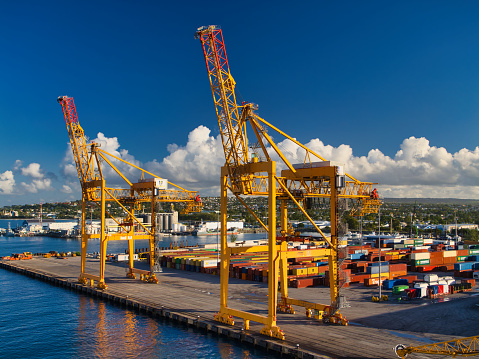Bridgetown, Barbados - Jan 28 2024: Container handling gantry cranes at the container terminal at the Port of Barbados, Bridgetown, Caribbean. Taken on a calm, sunny morning with a blue sky.